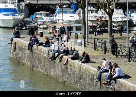 Menschen saßen am schwimmenden Hafen an einem sonnigen Tag im Frühling, Bristol, UK Stockfoto