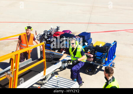 Gepäckabfertiger laden ein Flugzeug auf dem Rollfeld am Flughafen Barcelona, Katalonien, Spanien Stockfoto