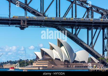 Sydney-Zug über Sydney Harbour Bridge mit Opernhaus im Hintergrund, Australien Stockfoto