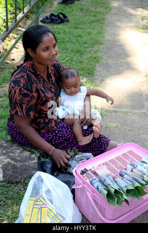 Aluviharaya Rock Cave Tempel Sri Lanka Matale Distrikt Kandy-Dambulla Autobahn Mutter mit Baby Girl Paan in Betel Blätter und Weihrauch-Sticks zu verkaufen Stockfoto