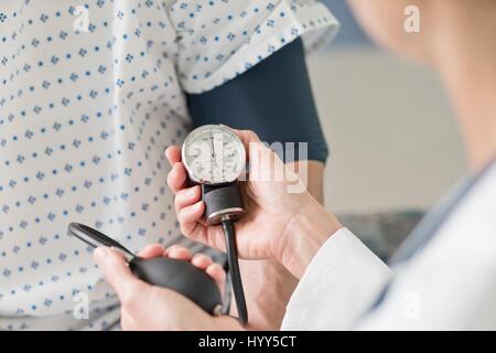 Arzt Blutdruck nehmen Patienten. Stockfoto