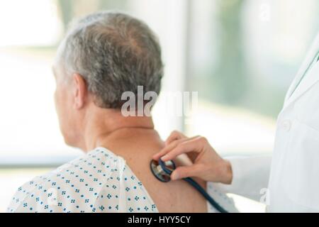 Ärztin mit Stethoskop auf männliche Patienten. Stockfoto