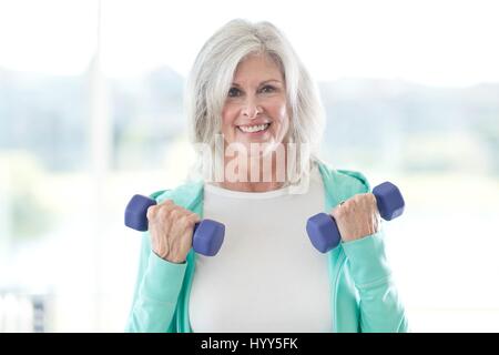 Ältere Frau mit Hanteln. Stockfoto