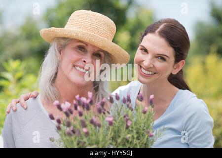 Ältere Frau und Tochter halten Topfpflanze. Stockfoto