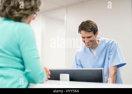 Krankenpfleger mit Computer mit Patientin. Stockfoto