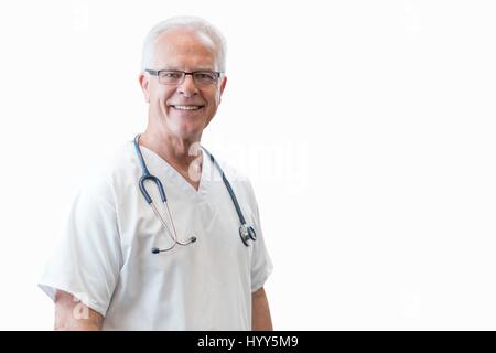 Senior männlichen Arzt lächelnd in Richtung Kamera, Porträt. Stockfoto
