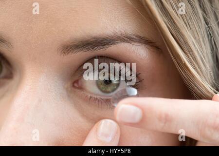 Mitte Erwachsene Frau Kontaktlinsen ins Auge. Stockfoto