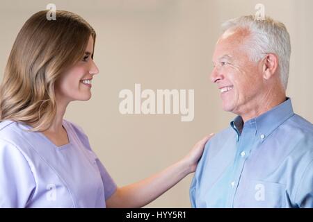 Mitte Erwachsene Frau mit der Hand auf die Schulter des älteren Mannes. Stockfoto