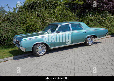 ROSMALEN, Niederlande - 8. Mai 2016: Seitenansicht von einem geparkten 1964 Oldsmobile F-85 Oldtimer. Stockfoto