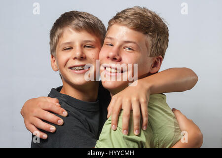 Zwei jungen umarmen einander, neutralem Hintergrund Stockfoto