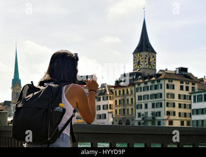 Mädchen nehmen Foto am Limmatquai und Saint Peter Church und Fraumünster Kirche im Zentrum von Zürich, in der Schweiz. Stockfoto