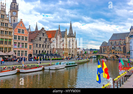 Gent, Belgien - 10. Mai 2012: Zunfthäuser und Clock Tower des ehemaligen Postgebäudes in Graslei, Gent, Ost-Flandern, Belgien. Menschen am Kanal Leie Stockfoto