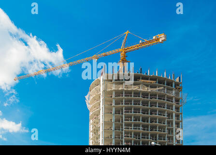 Kran und Hochhaus unter Bauarbeiten. Stockfoto