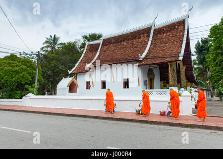 Luang Prabang, Laos - 22. Juni 2014: buddhistischen Mönchen Almosen von den Leuten auf der Straße von Luang Prabang, Laos am 22. Juni 2014. Stockfoto