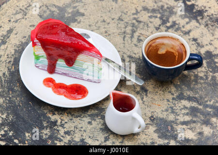 Crêpe Kuchen Rainbow und heißen Espresso-Kaffeemaschine im Gartenseite nach Hause. Krepp-Kuchen mit Erdbeersauce Stockfoto