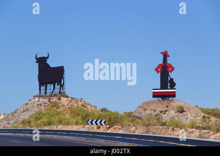 Bull Metall Figur und Mann mit Hut und Gitarre Figur entlang der Straße in Sevilla, Andalusien, Spanien. Stockfoto