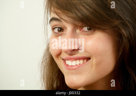 Junge Frau lächelt, schaut in die Kamera. Schließen Sie die Ansicht. Stockfoto