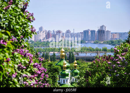 Ikonische Blick auf ein Kloster Vydubitsky und Dnjepr von einem botanischen Garten Kiew mit blühenden Flieder, Ukraine.; Stockfoto