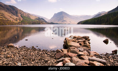 Die Berge Fleetwith Hecht und riesigen Heuhaufen erheben sich über dem See am Buttermere im englischen Lake District. Stockfoto