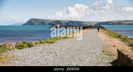 Fishguard, Wales, UK - 21. Mai 2009: Wanderer Spaziergang auf der Mole in Fishguard, mit blauen Meer und die Klippen der Küste von Pembrokeshire. Stockfoto