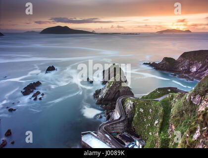 Ein engen gewundenen Pfad führt steilen Klippen hinunter nach Dunquin Pier mit den Blasket Inseln hinaus an der felsigen Atlantikküste der Dingle-Halbinsel in Stockfoto