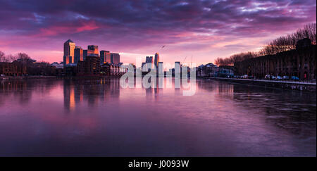 Sonnenaufgang auf die Wolkenkratzer und Bürogebäude der Londoner Docklands Geschäftsviertel spiegelt sich in den Gewässern von Greenland Dock in Rotherhithe. Stockfoto