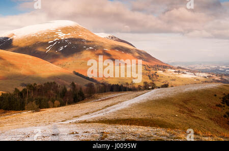 Winterschnee liegt auf dem Gipfel des markanten runden Berg Saddleback, auch bekannt als Blencathra, über Keswick im englischen Lake District. Stockfoto