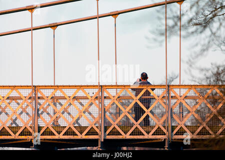 Eine Person, die auf dem Fluss Dee Hängebrücke, die über den Fluss Dee in Chester von Handbridge in die Stadt durchquert, während fotografieren Stockfoto