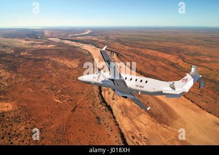 Eine Luftaufnahme des eine Beechcraft B1900D Kurzstrecke / charter Flugzeug Banking über das australische Outback. Stockfoto