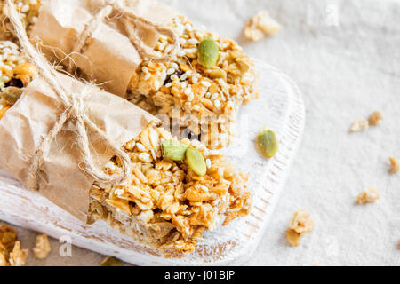 Organischen hausgemachte Müsliriegel auf rustikalen hölzernen Hintergrund - gesunde vegetarische vegane Diät Snack Müsliriegel mit Nüssen, Samen, Honig und Getreide Stockfoto