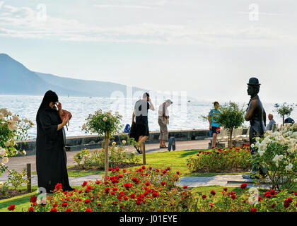 Vevey, Schweiz - 27. August 2016: Menschen an Charlie Chaplin-Statue am Genfersee, Vevey, Kanton Waadt, Schweiz. Alpen Berge auf der staatlich Stockfoto