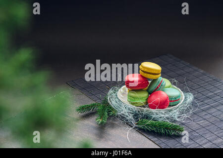 Winter-Stillleben mit traditionelle französische Macarons auf die kleine Platte und Tanne Äste. Platz für Ihren Text oben auf das Bild Stockfoto