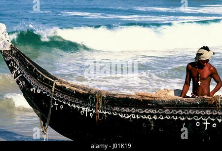 Christian Fischer mit seinem Boot am Strand von Kovalam in Kerala, Indien. Stockfoto