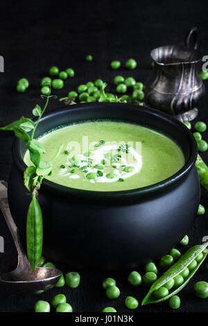 Grüne Erbsen Suppe auf dunklem Holz. Niedrige Schlüsselfoto. Stockfoto