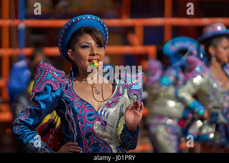 Caporales Tänzerin in kunstvollen Kostümen, die Durchführung, wie sie durch die Bergbau-Stadt Oruro auf dem Altiplano von Bolivien während der jährliche Karneval parade Stockfoto
