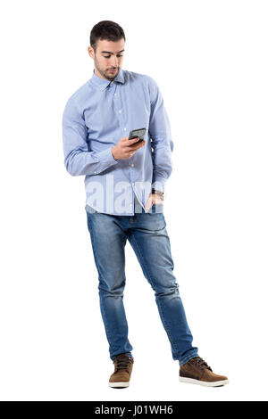 Entspannte junge smart casual Business-Mann Nachricht auf dem Handy zu schreiben. Ganzkörper-Länge-Porträt isoliert auf weißem Hintergrund. Stockfoto