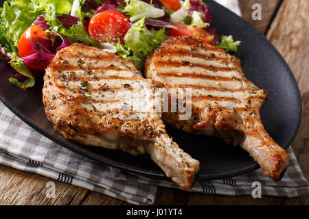 Grill pikante Kotelett mit Salat aus frischem Gemüse Nahaufnahme auf Platte. horizontale Stockfoto