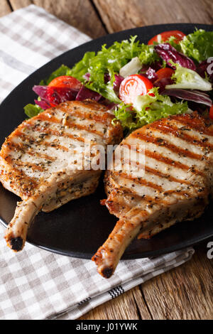 BBQ Schweinefleisch Schnitzel mit gemischtem Salat auf eine Platte Nahaufnahme auf dem Tisch. vertikale Stockfoto
