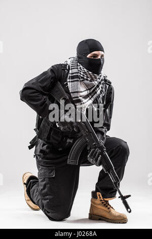 Terrorismus-Konzept: Terrorist mit einem Maschinengewehr in den Händen isoliert auf weiß Stockfoto