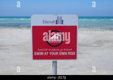 Warnschild in arabischer und englischer Sprache: Schwimmen auf eigene Gefahr, Al Jazayer Beach, Königreich Bahrain Stockfoto