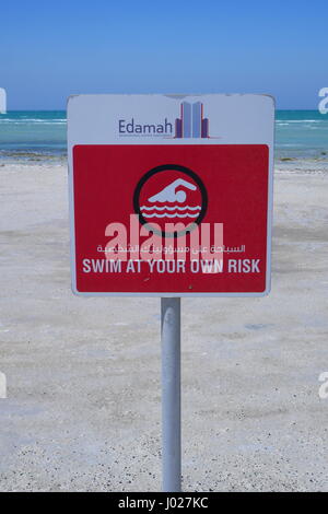 Warnschild in arabischer und englischer Sprache: Schwimmen auf eigene Gefahr, Al Jazayer Beach, Königreich Bahrain Stockfoto