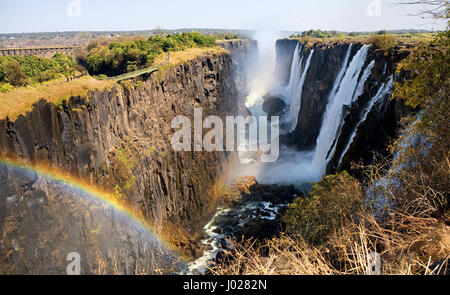 Viktoriafälle. Gesamtansicht mit einem Regenbogen. Nationalpark. Mosi-Oa-Tunya Nationalpark. und UNESCO-Weltkulturerbe. Zambiya. Zimbabwe. Stockfoto