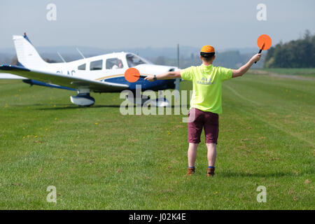 Shobdon Flugplatz, Herefordshire, England. April 2017. Allgemeine Luftfahrt Flugplatz Boden Flughelfer leitet ein taxying Flugzeug Piper Pa-28 Cherokee. Bildnachweis: Steven Mai / Alamy Live News Stockfoto