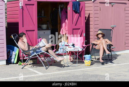 Bournemouth, Dorset, Großbritannien, 9.. April 2017. Dieses Paar war in den rosafarbenen Tönen, als es vor einer rosafarbenen Strandhütte saß, als die Temperaturen heute in Südengland bis in die frühen zwanziger Jahre anstiegen, obwohl es erst Anfang April war und viele Leute den Tag an der Küste verbrachten, um den Sommer früh zu probieren. Stockfoto