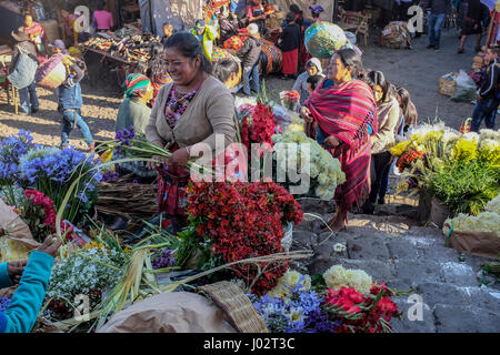 Eine Maya-Frau verkauft Blumen vor der Kirche am Sonntagsmarkt in Chichicastenango, Guatemala. Stockfoto