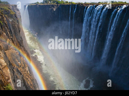 Viktoriafälle. Gesamtansicht mit einem Regenbogen. Nationalpark. Mosi-Oa-Tunya Nationalpark. und UNESCO-Weltkulturerbe. Zambiya. Zimbabwe. Stockfoto