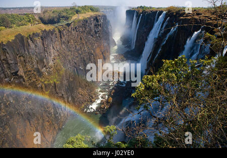 Viktoriafälle. Gesamtansicht mit einem Regenbogen. Nationalpark. Mosi-Oa-Tunya Nationalpark. und UNESCO-Weltkulturerbe. Zambiya. Zimbabwe. Stockfoto