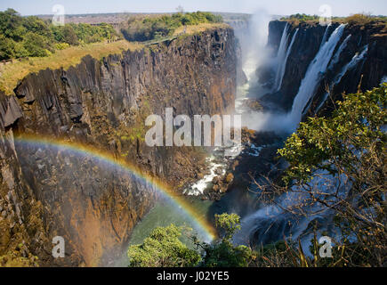 Viktoriafälle. Gesamtansicht mit einem Regenbogen. Nationalpark. Mosi-Oa-Tunya Nationalpark. und UNESCO-Weltkulturerbe. Zambiya. Zimbabwe. Stockfoto