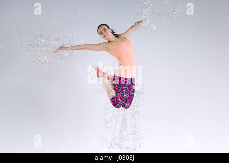 Frau im Studio springen und Spritzwasser Stockfoto