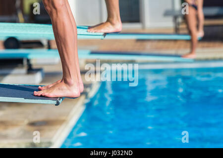 Aquatische Tauchen Taucher Füße Beckenrand Board für Backflip in Schwimmbad abstrakte Closeup unbekannten Athleten. Stockfoto
